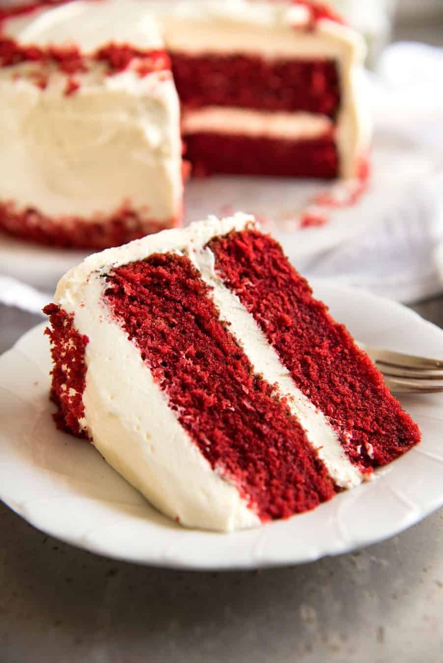 A slice of Red Velvet Cake on a white plate, ready to be eaten.